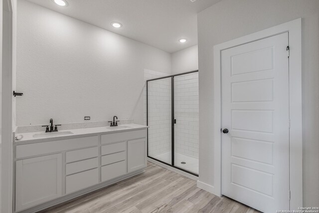 bathroom featuring hardwood / wood-style floors, vanity, and an enclosed shower