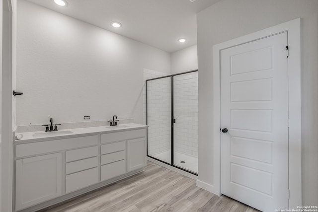 bathroom with vanity, a shower with door, and hardwood / wood-style floors