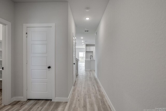 hall with sink and light hardwood / wood-style floors