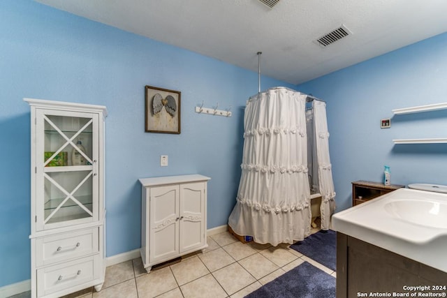 bathroom featuring tile patterned flooring, a textured ceiling, and vanity