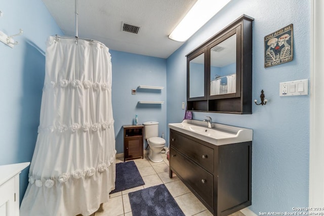 bathroom featuring vanity, tile patterned floors, a shower with curtain, toilet, and a textured ceiling