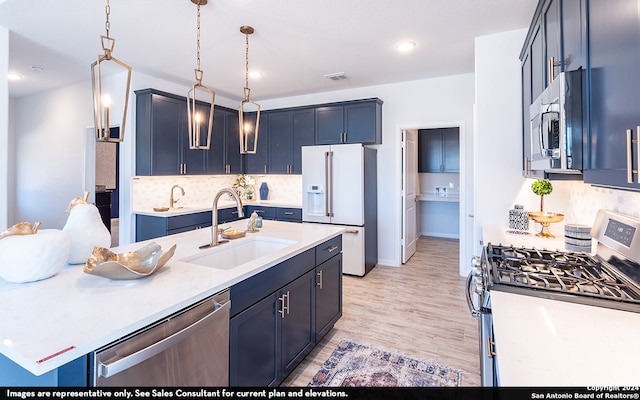 kitchen with tasteful backsplash, an island with sink, light wood-type flooring, appliances with stainless steel finishes, and sink