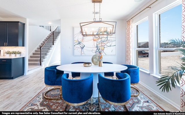 dining area with an inviting chandelier and light hardwood / wood-style flooring