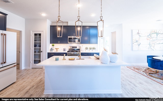 kitchen featuring light hardwood / wood-style floors, a center island with sink, high end fridge, backsplash, and gas range