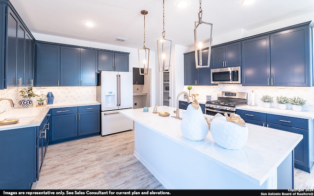 kitchen featuring stainless steel appliances, a center island with sink, decorative light fixtures, light wood-type flooring, and blue cabinets