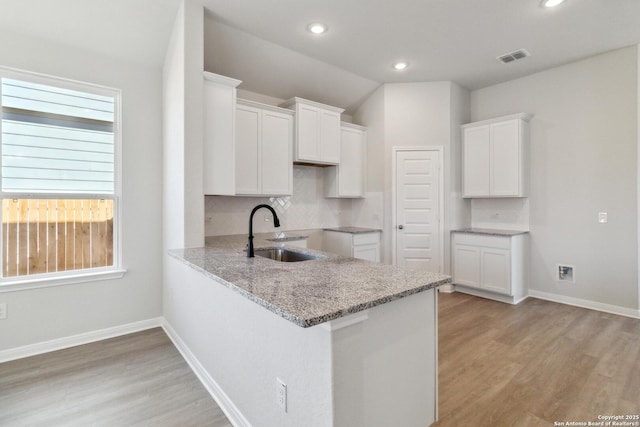 kitchen featuring white cabinets, sink, a wealth of natural light, and tasteful backsplash