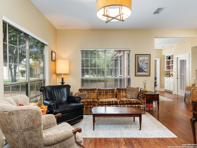 living room with dark hardwood / wood-style floors and a chandelier