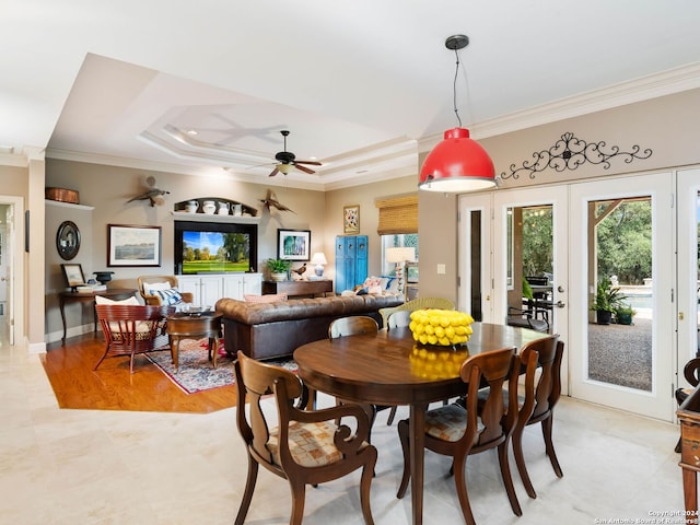 dining space featuring a raised ceiling, french doors, crown molding, and ceiling fan