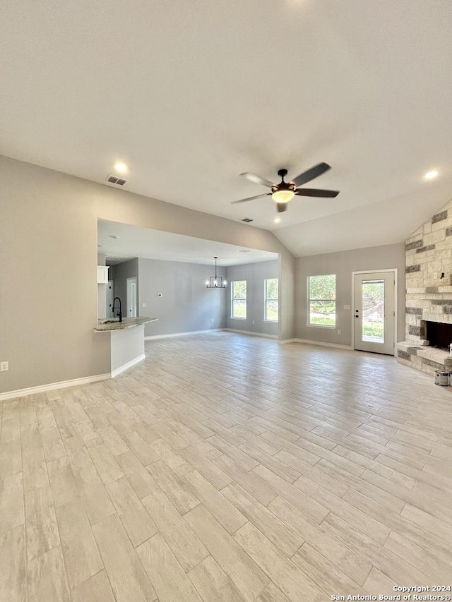 unfurnished living room with ceiling fan with notable chandelier and sink