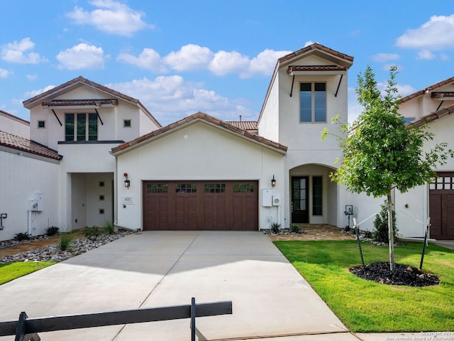 mediterranean / spanish home with a garage and a front yard