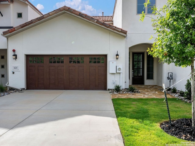 mediterranean / spanish-style home featuring a garage and a front yard