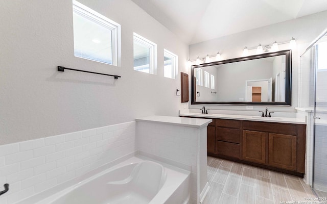 bathroom featuring vanity, lofted ceiling, and shower with separate bathtub