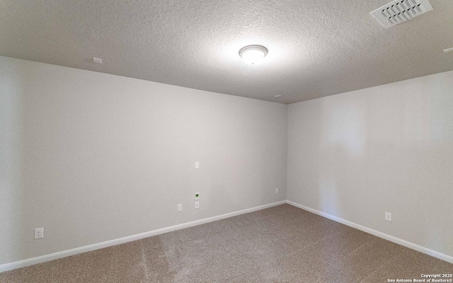 carpeted spare room featuring a textured ceiling