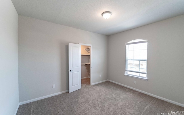 carpeted spare room with a textured ceiling