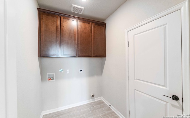 laundry room with cabinets, hookup for a washing machine, a textured ceiling, hookup for an electric dryer, and light hardwood / wood-style floors