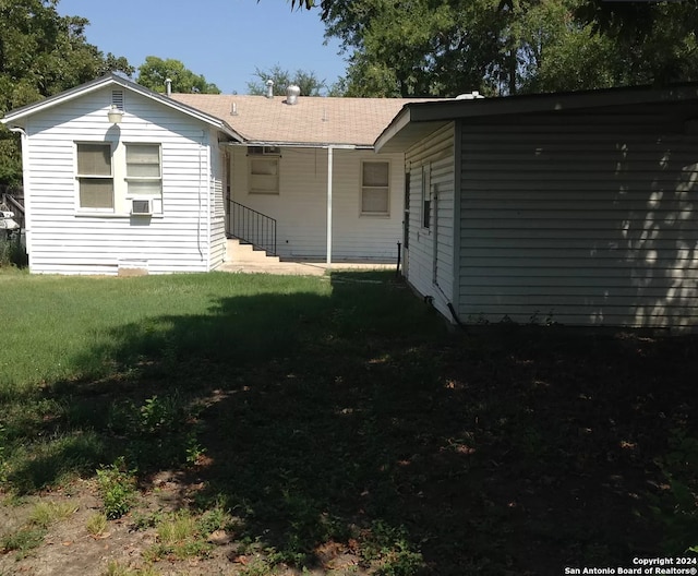 rear view of property featuring a yard