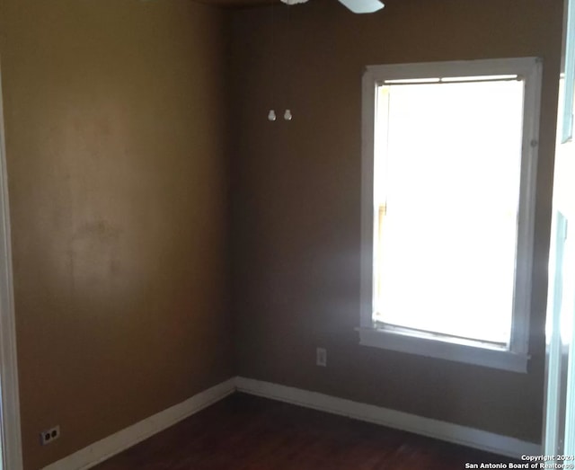 spare room featuring ceiling fan and dark hardwood / wood-style floors