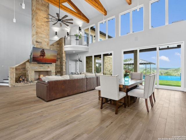 dining room featuring high vaulted ceiling, a fireplace, and wood-type flooring