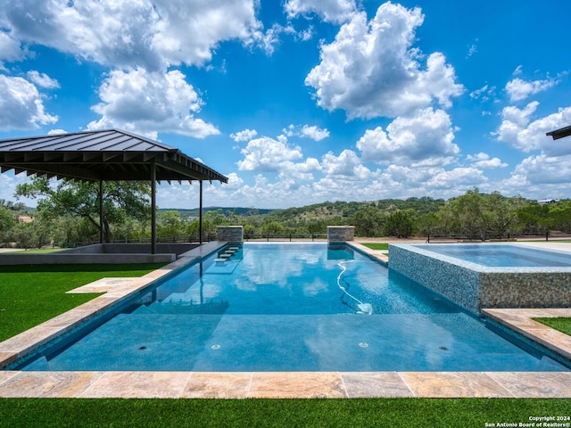 view of swimming pool with an in ground hot tub