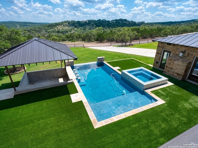 view of pool with an in ground hot tub and a yard