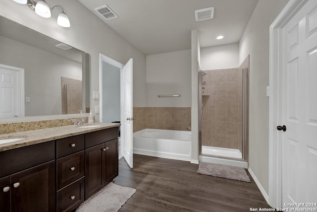 bathroom featuring hardwood / wood-style flooring, vanity, and shower with separate bathtub