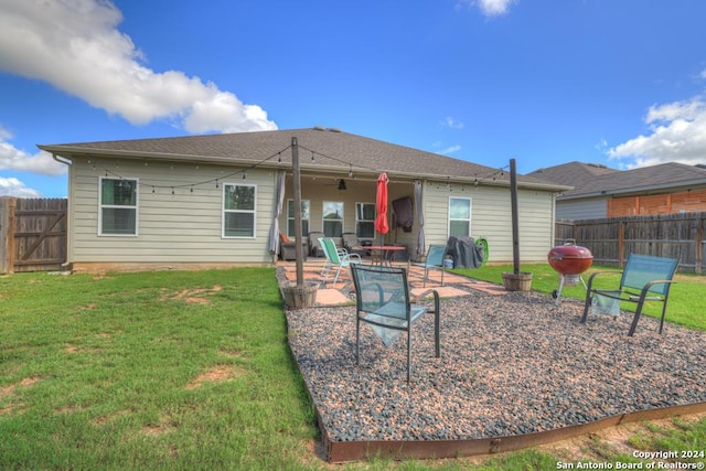 back of property with a lawn, ceiling fan, and a patio area