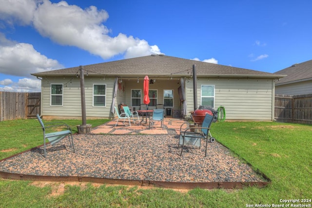 rear view of house with a lawn and a patio area