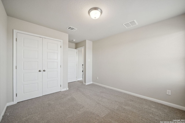 unfurnished bedroom with carpet and a closet