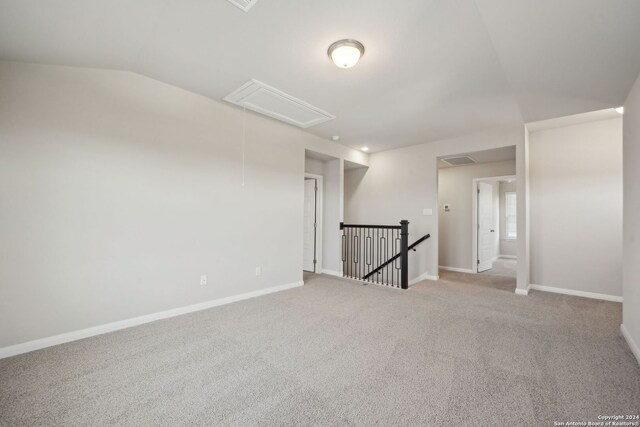 carpeted empty room featuring lofted ceiling