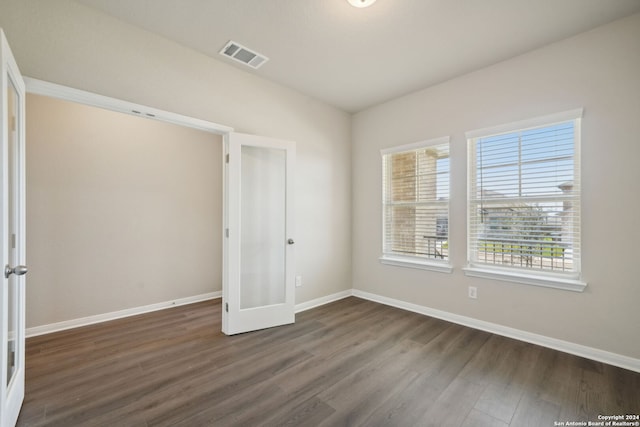 unfurnished bedroom featuring french doors and dark hardwood / wood-style floors