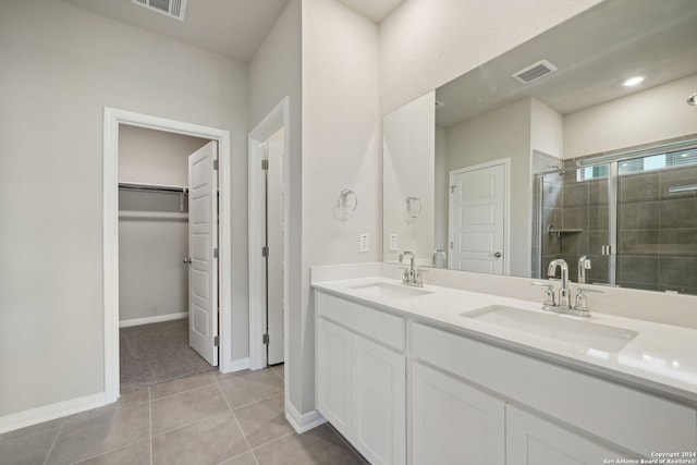 bathroom featuring tile patterned flooring, vanity, and a shower with door