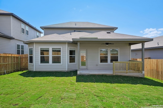 rear view of property featuring a yard, ceiling fan, and a patio area