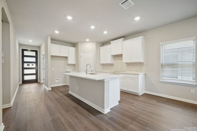 kitchen featuring white cabinets, sink, an island with sink, and dark wood-type flooring