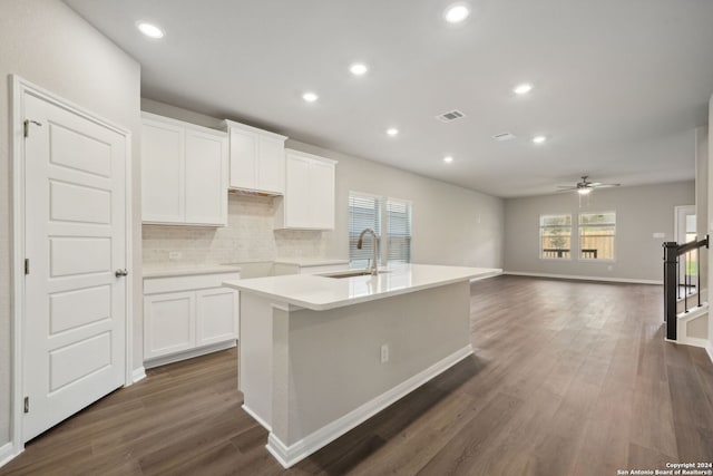 kitchen with an island with sink, white cabinetry, ceiling fan, and sink