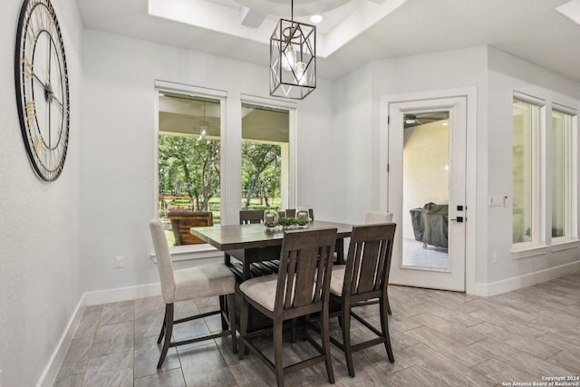 dining area with a tray ceiling and an inviting chandelier