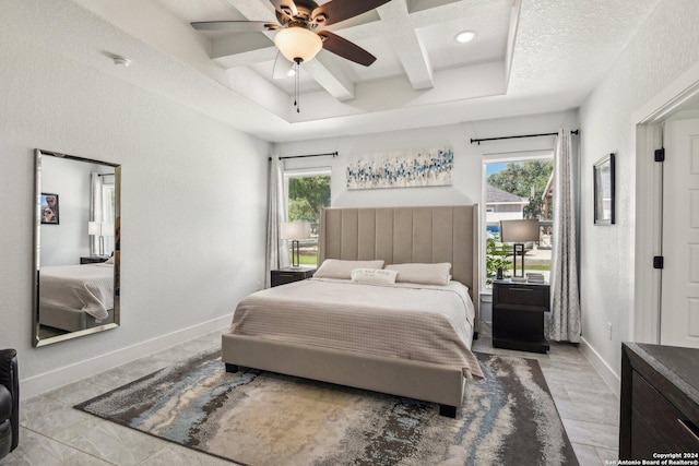 bedroom with ceiling fan, beam ceiling, multiple windows, and coffered ceiling