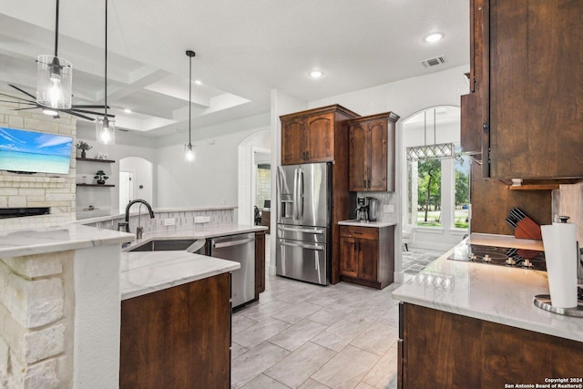 kitchen featuring decorative backsplash, stainless steel appliances, light stone counters, and hanging light fixtures