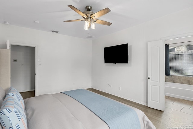 bedroom featuring hardwood / wood-style floors, ensuite bathroom, and ceiling fan