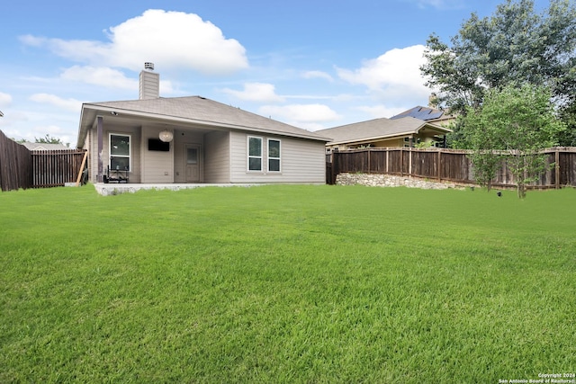 rear view of property featuring a lawn