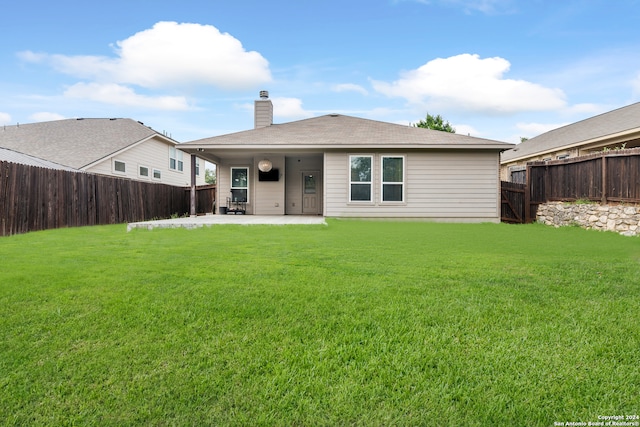 back of property with a yard and a patio area