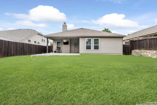 rear view of property with a lawn and a patio