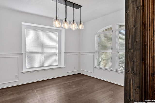 unfurnished dining area with dark wood-type flooring