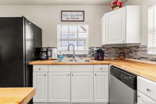 kitchen featuring white cabinetry, dishwasher, sink, wooden counters, and black refrigerator