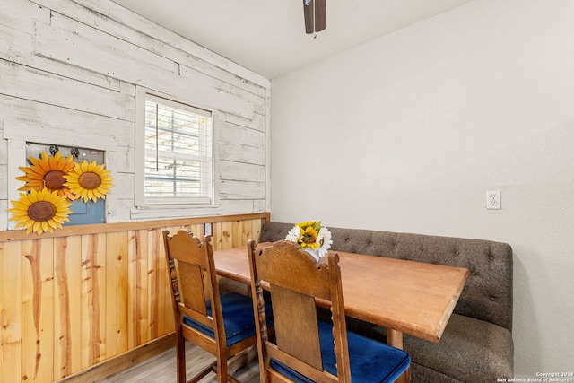 dining space with hardwood / wood-style floors and wooden walls