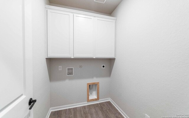 washroom with gas dryer hookup, hardwood / wood-style floors, cabinets, washer hookup, and electric dryer hookup