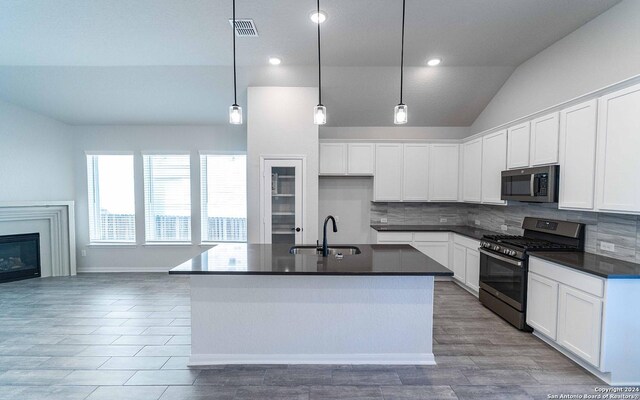 kitchen featuring sink, white cabinetry, hanging light fixtures, a center island with sink, and appliances with stainless steel finishes