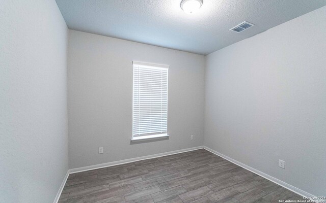 spare room with hardwood / wood-style flooring and a textured ceiling