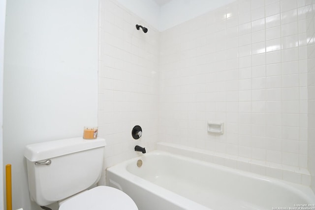 bathroom with toilet and tiled shower / bath