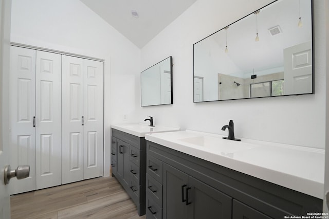 bathroom featuring a shower, vanity, wood-type flooring, and lofted ceiling