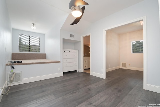 unfurnished bedroom with ceiling fan, dark wood-type flooring, and connected bathroom